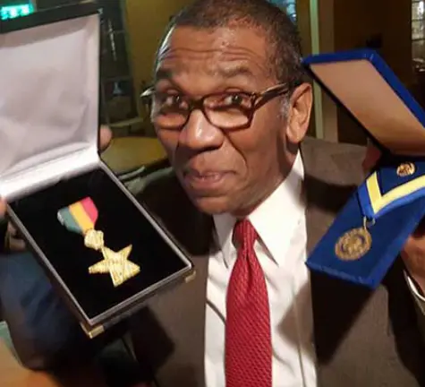 A man holding up a medal in his hand.